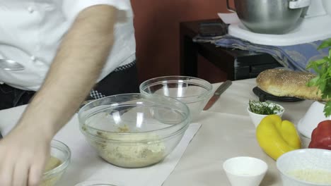 chef vertiendo aceite y sal en un cuenco mezclando ingrediente para la preparación de alimentos