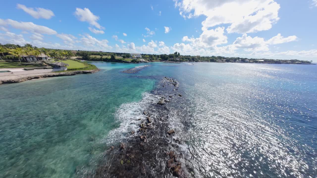 High speed FPV fly over Caleton Beach, Casa De Campo La Romana, Dominican Republic. The blue bay and white sand beach.