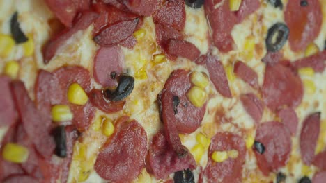 close-up of a pepperoni, corn, and olive pizza