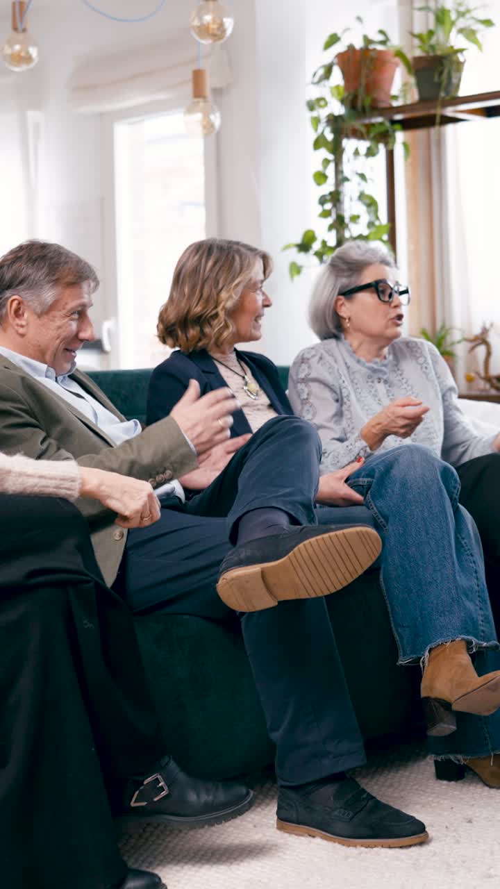 Gruppe af modne venner i samtale på en sofa