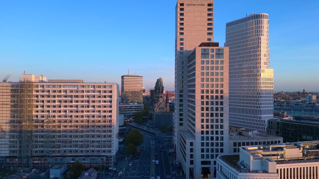 Estación de tren Zoologischer Garten y el paisaje urbano circundante en Berlín, Alemania, durante el atardecer. Gran vista aérea con rampa de velocidad de vuelo y time-lapse de hipermovimiento