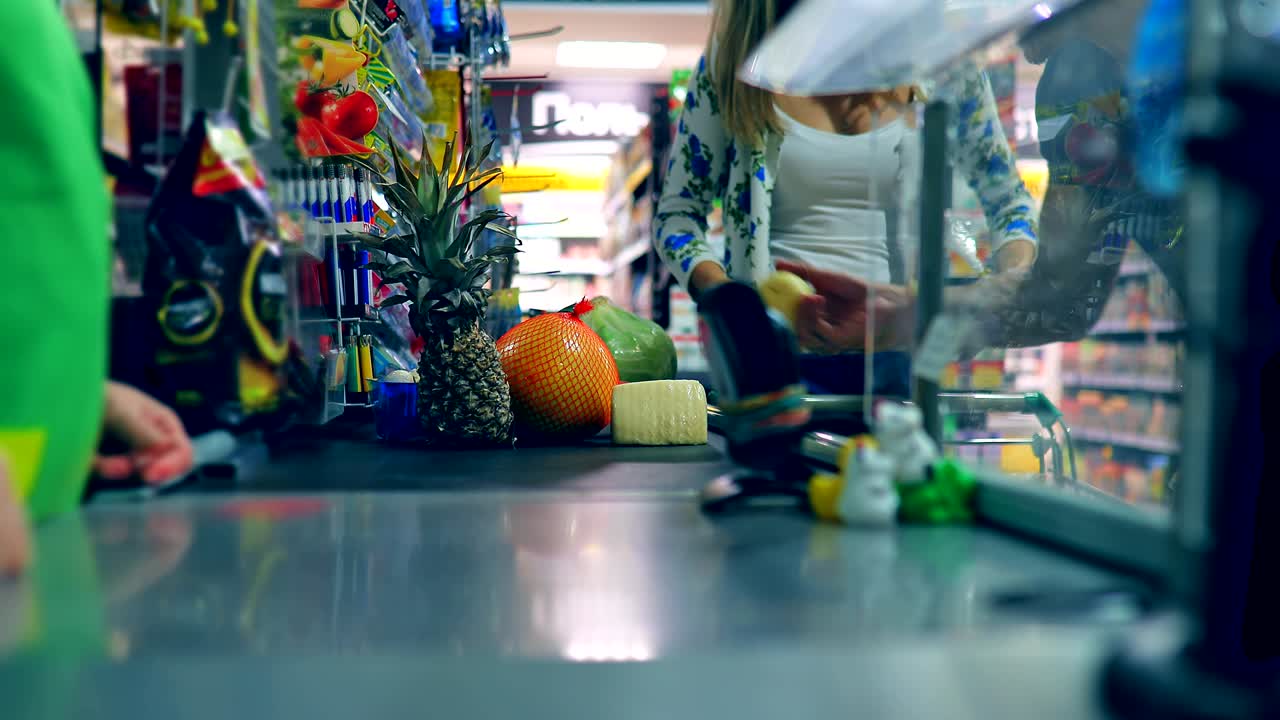 음식과 함께 현금 테이크 근처의 커플 소년과 소녀는 현금 데스크에 음식을 놓고 있습니다.