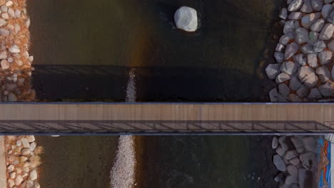 Overhead-view-of-pedestrian-bridge-going-over-the-Truckee-River-in-Reno,-Nevada-with-a-scroll-down