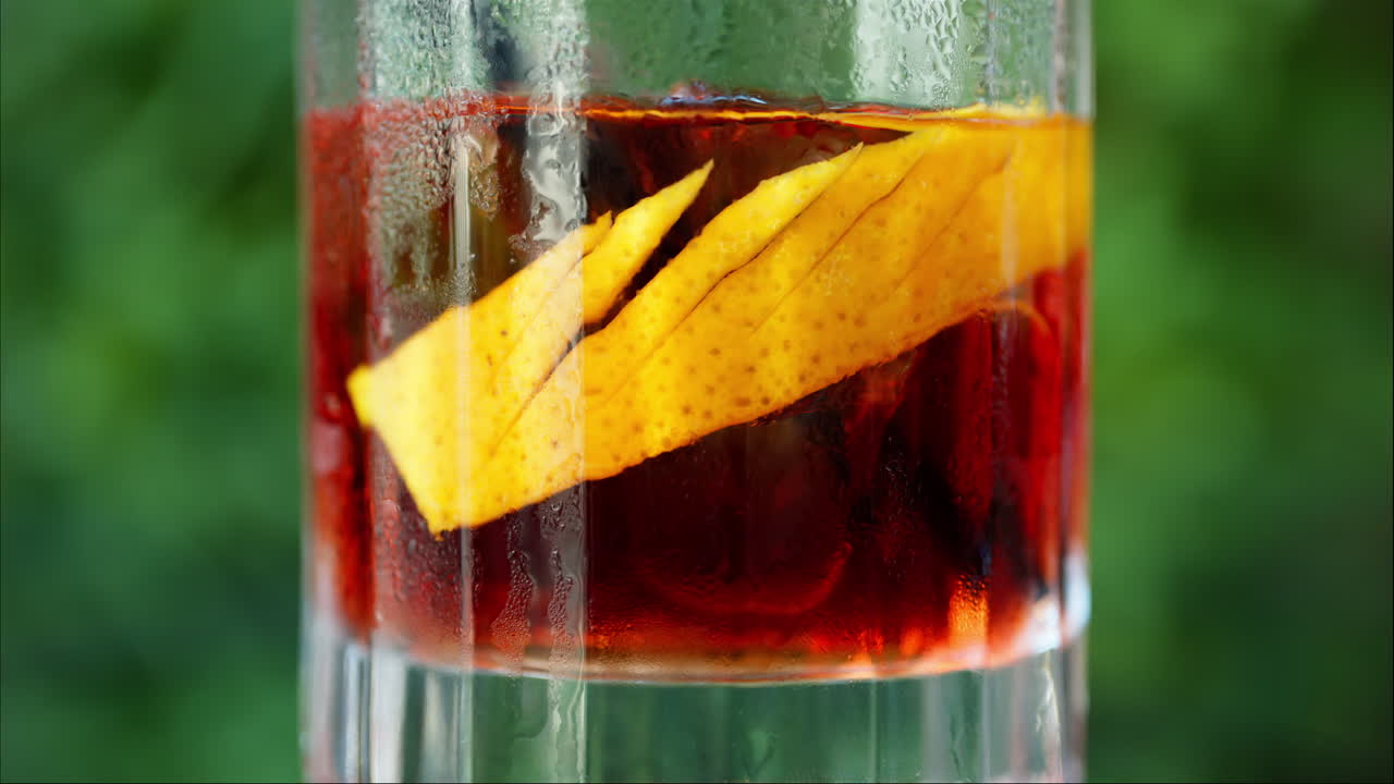 Primo piano di un cocktail Negroni su sfondo verde