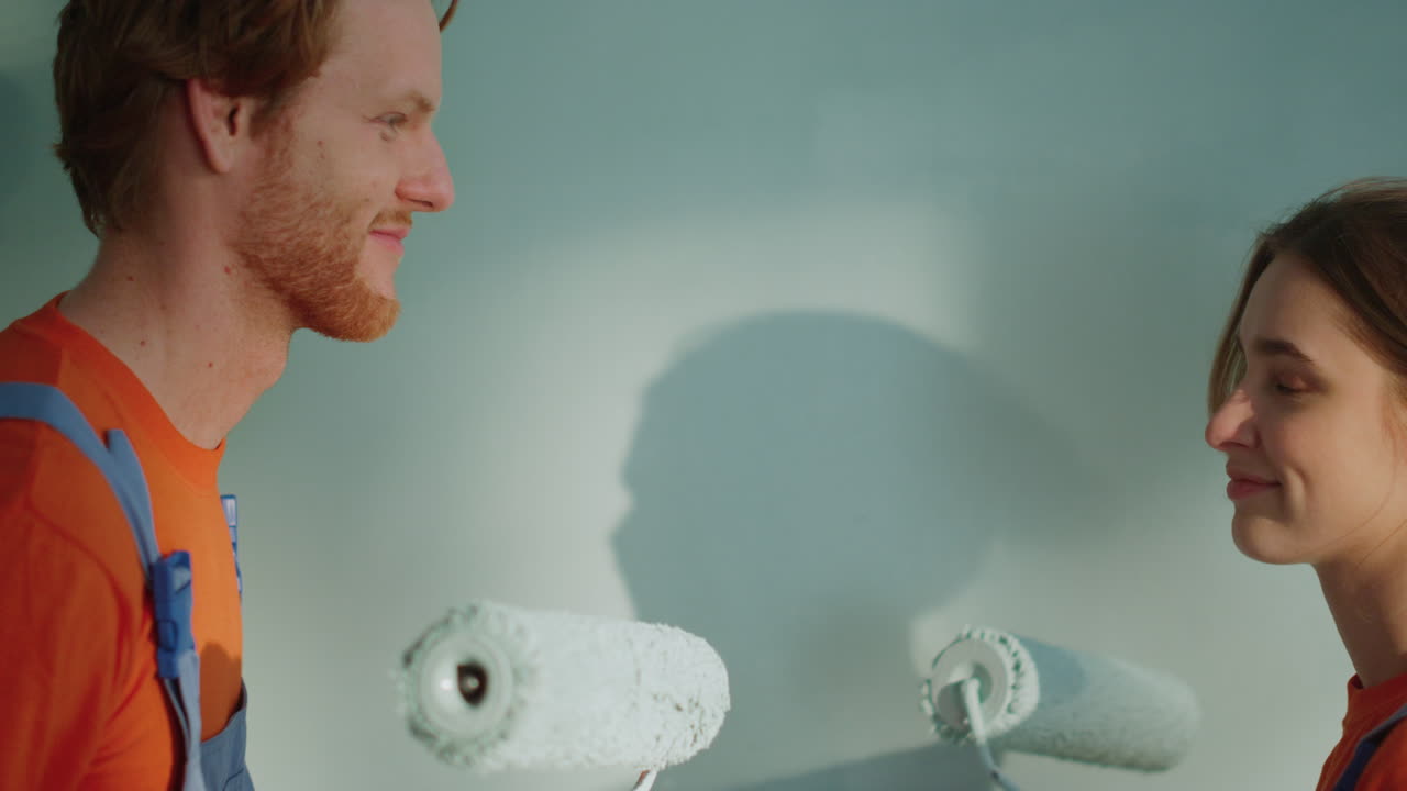 игровая семья делает декоративные работы в помещении. пара рисует вместе в доме.