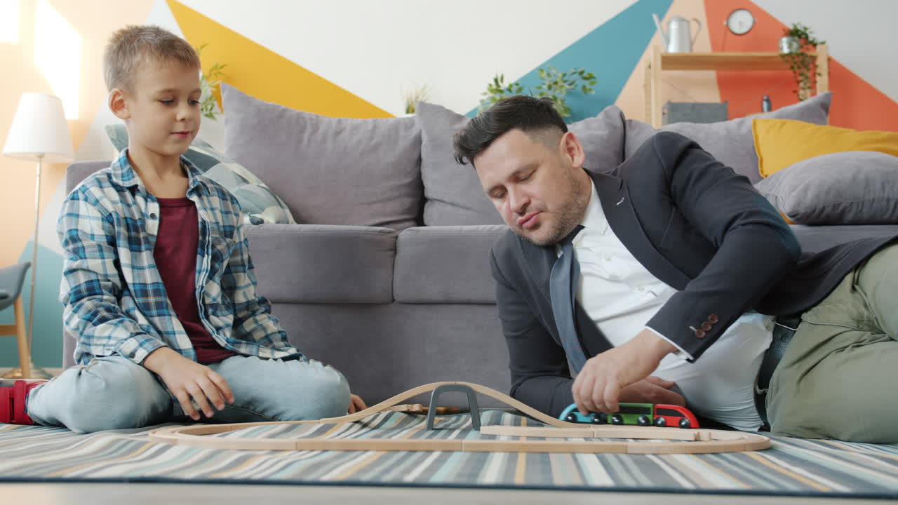 Father and Son Playing with Wooden Train Set