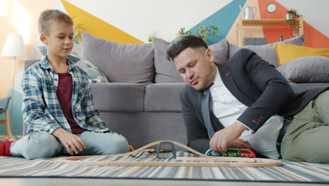father and son playing with wooden train set
