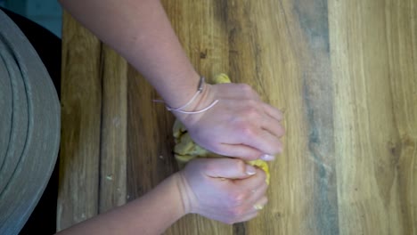 vertical - mujer amasando masa en un mostrador de cocina