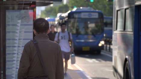 man waiting at bus stop in seoul