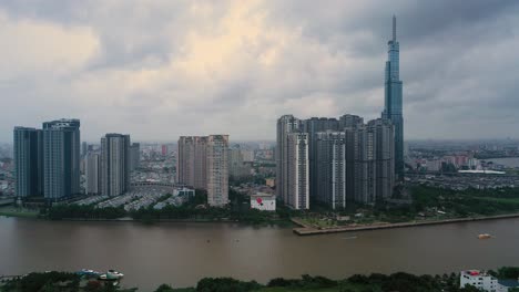 Vista-Aérea-Del-Parque-Central-Y-Rascacielos-Emblemáticos-En-El-Río-Saigon-En-La-Ciudad-De-Ho-Chi-Minh,-Vietnam-En-Un-Clima-Nublado-Y-Lluvioso