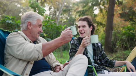 Grandfather and Grandson Enjoying Coffee While Camping
