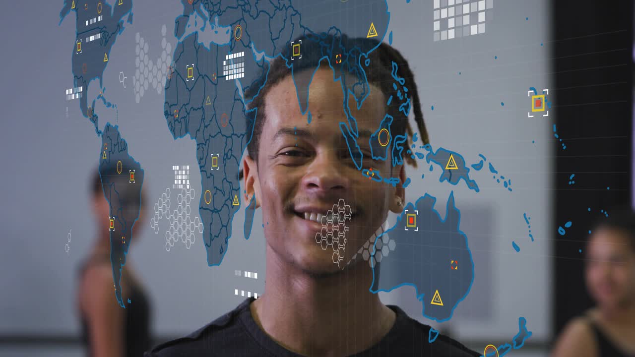 Hombre adulto de pie, mirando a la cámara en un estudio con un mapa tecnológico que muestra rejillas hexagonales animadas para datos, sonriendo