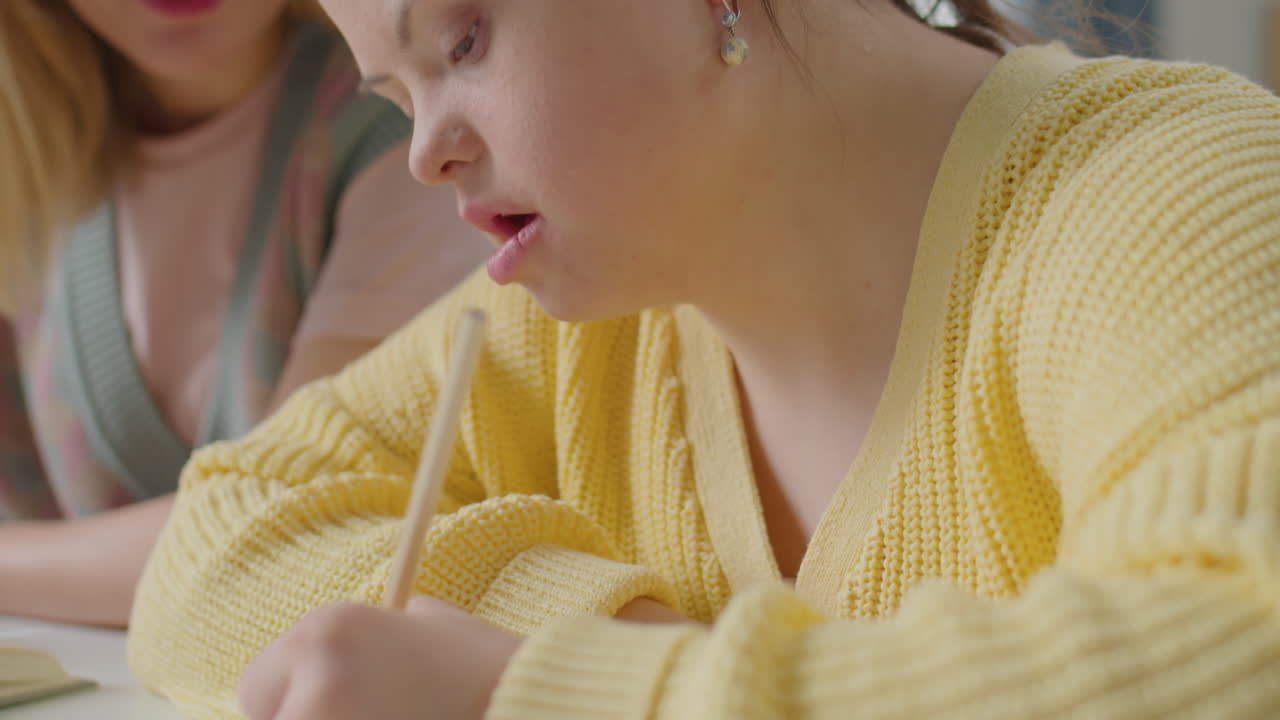 Girl with Down Syndrome Having Lesson with Teacher at Home