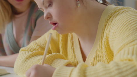girl with down syndrome having lesson with teacher at home