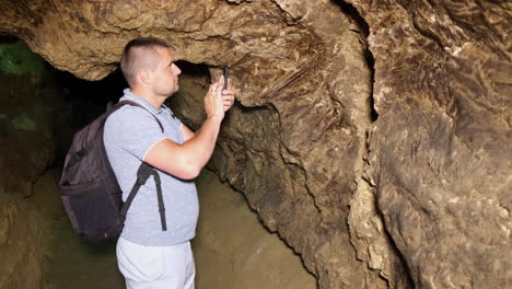 tourist with a backpack in the cave speleology cave dungeon tourist with a backpack in the cave speleology cave dungeon dark tunnel underground excavations