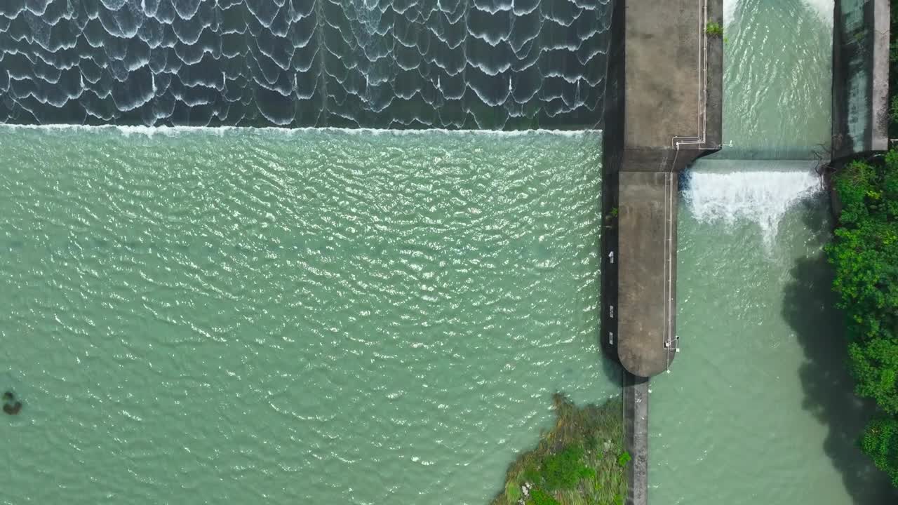 River Dam in Taiwan during sunny day with splashing water of reservoir lake