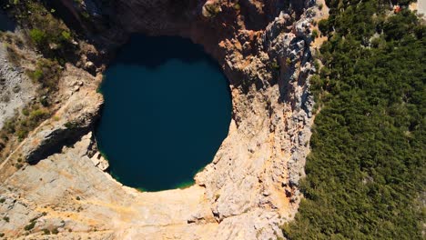 flying over the red lake containing a karst lake close to imotski, croatia