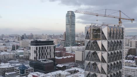 Cityscape with Construction of a Modern Skyscraper in Winter