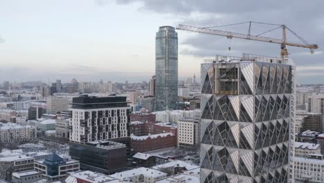 cityscape with construction of a modern skyscraper in winter