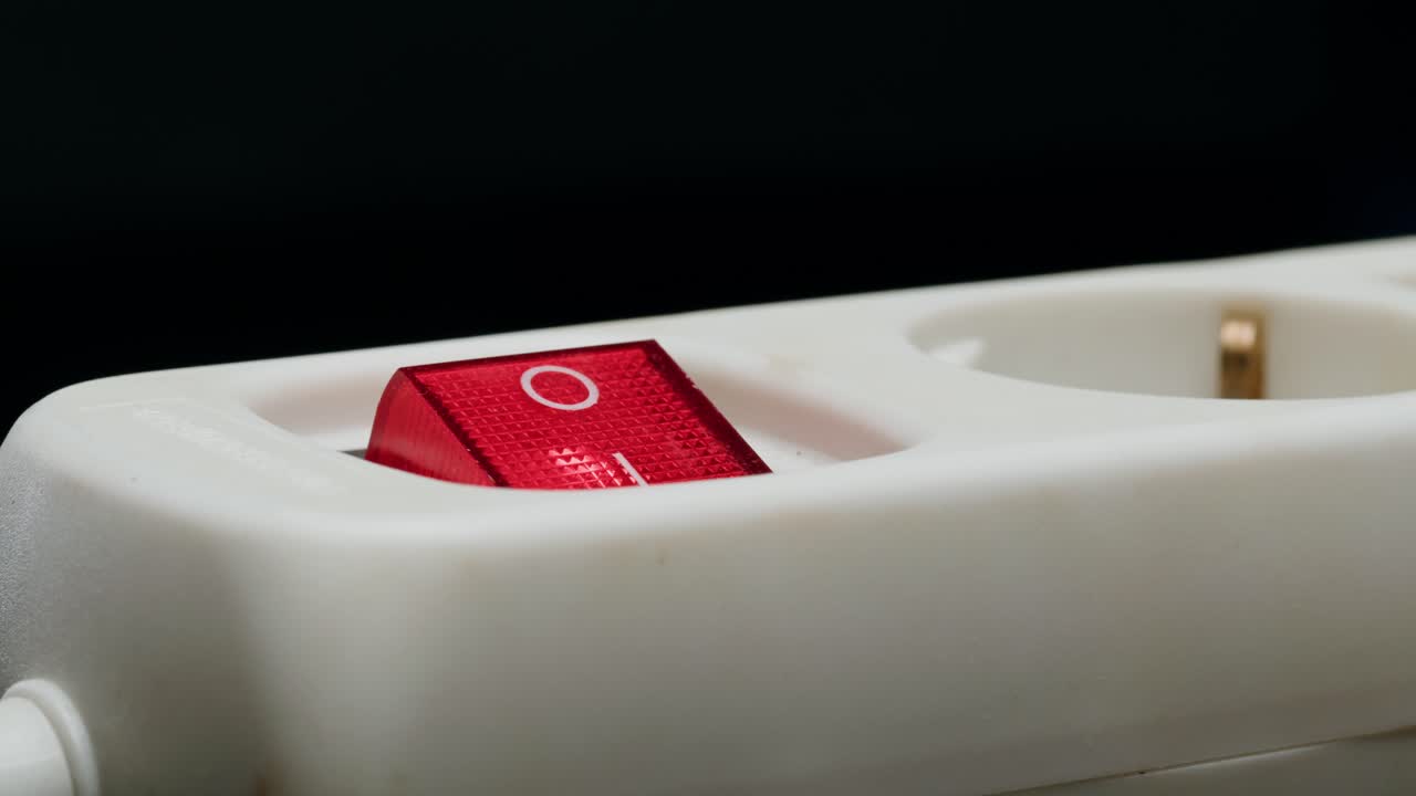 Close-up of a power strip switch being pressed