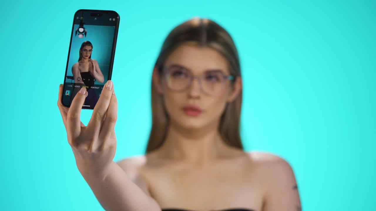 mujer rubia caucásica toma un retrato selfie con un teléfono celular croma de fondo hermoso modelo
