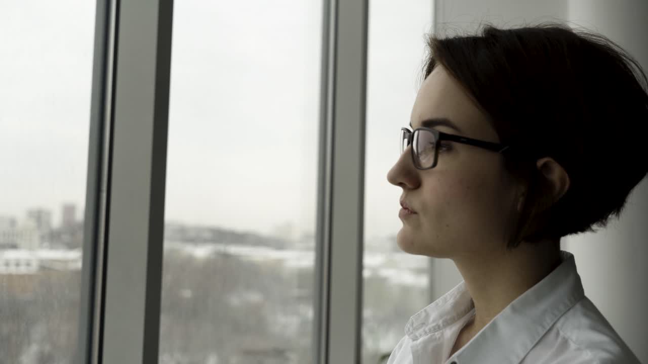 Una mujer mirando por la ventana.