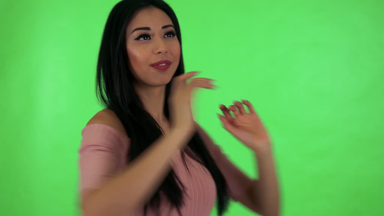 una joven asiática atractiva baila en el estudio de pantalla verde.