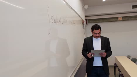 man writing a formula in a lecture hall