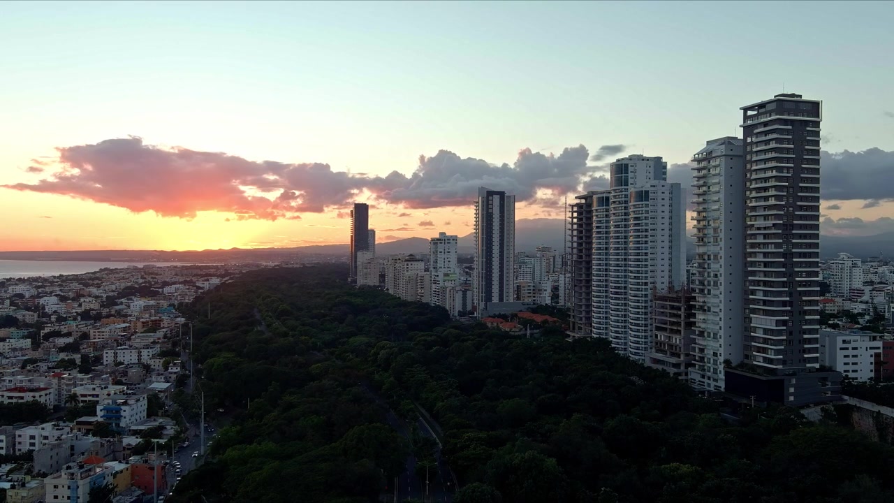 Time-lapse of clouds moving in sky with blinding setting sun in background, Santo Domingo city at sunset