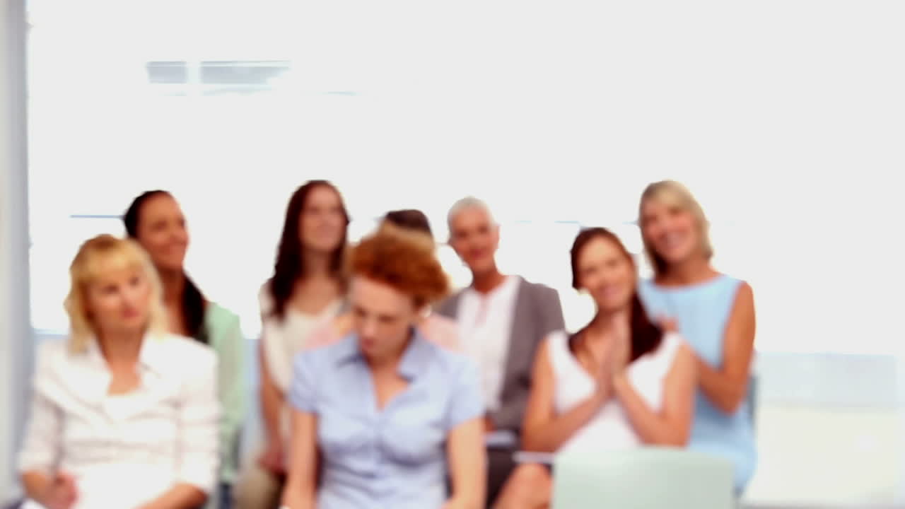 사업가 여성들이 동료에게 박수를 치고 있습니다.