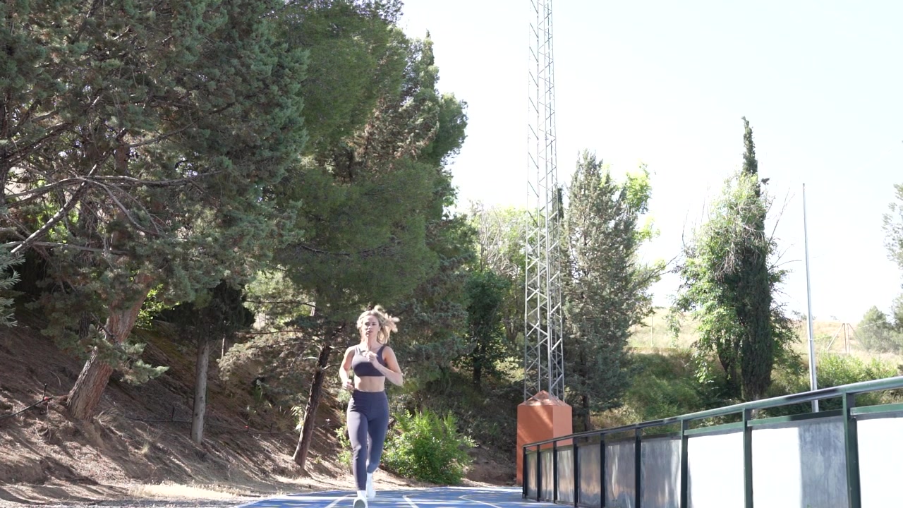 Una donna corre su un sentiero naturale, mostrando il suo impegno per il fitness e il benessere.
