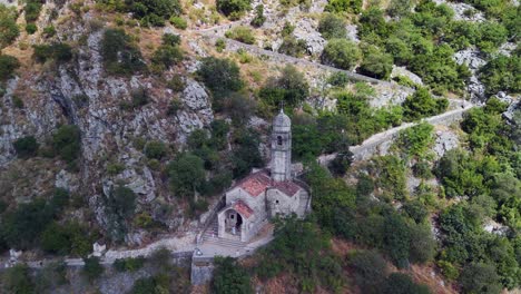 tourists climb stone staircase above lady of remedy church, kotor mne