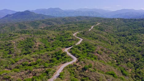 rural road snaking through pristine landscape of san juan de la maguana, dominican republic