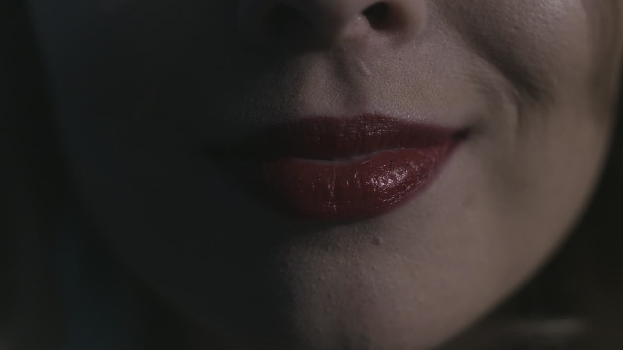 primer plano de la boca de una mujer con lápiz labial rojo
