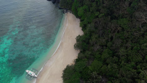 Drohnenaufnahme-Eines-Einsamen-Bootes,-Das-Am-Weißen-Sandstrand-Auf-Einer-Abgelegenen-Insel-Verankert-Ist