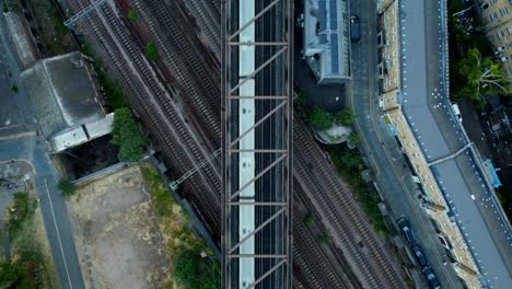 Birds-eye-view-drone-shot-train-travelling-through-urban-English-city