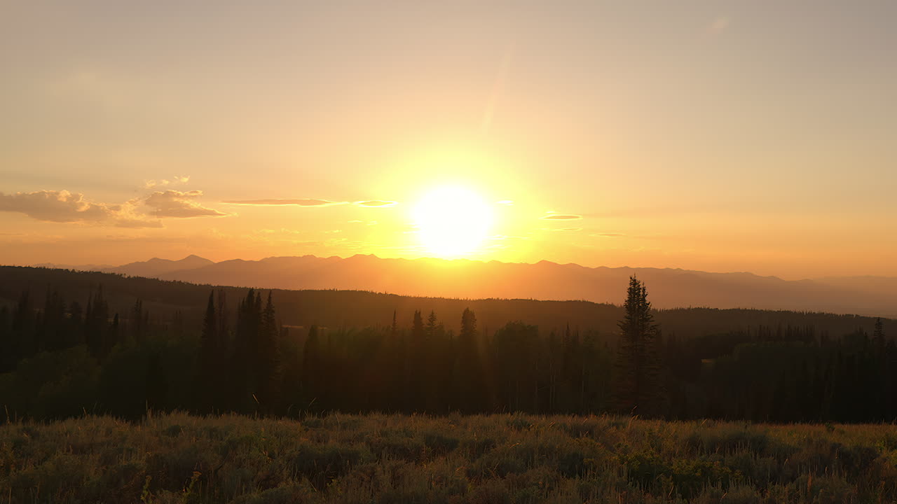 cálido cielo dorado campo montaña y bosque durante la puesta del sol