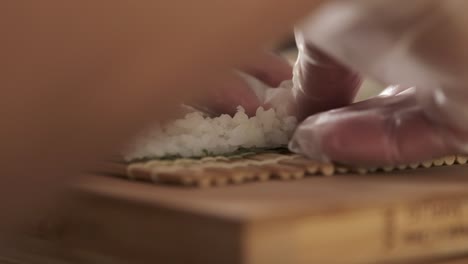 chef preparing sushi rolls in the kitchen