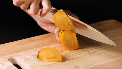 hands slicing persimmon with a sharp knife