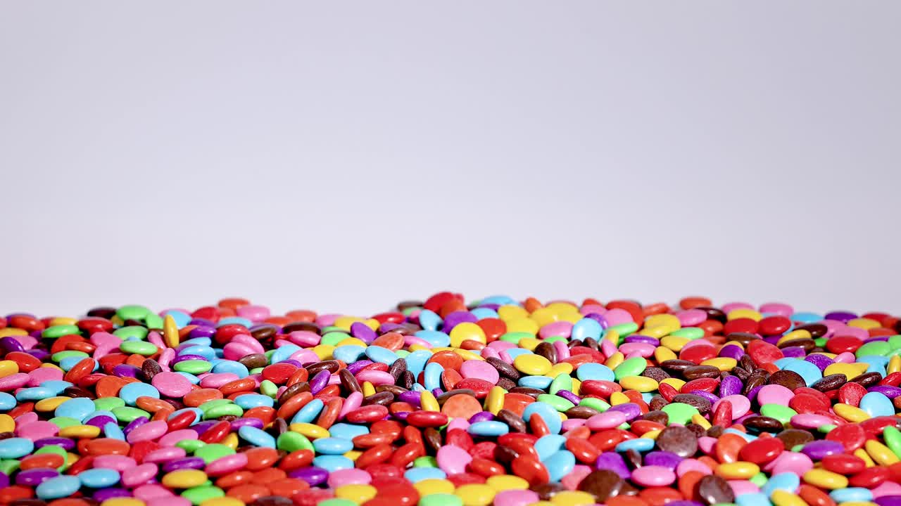 los caramelos vibrantes caen en cascada en una pila creciente