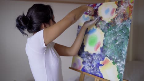 Artist-with-dirty-hands-painting-on-canvas