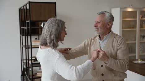 feliz casal sênior dançando e se abraçando em casa 1