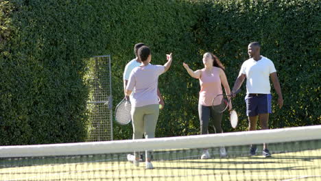 playing tennis, group of diverse friends celebrating on court with rackets in hand