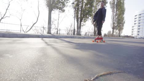 young-man-skates-on-his-longboard-on-the-road-in-the-city