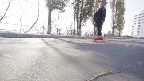 young man skates on his longboard on the road in the city