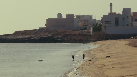 children playing on the beach near buildings
