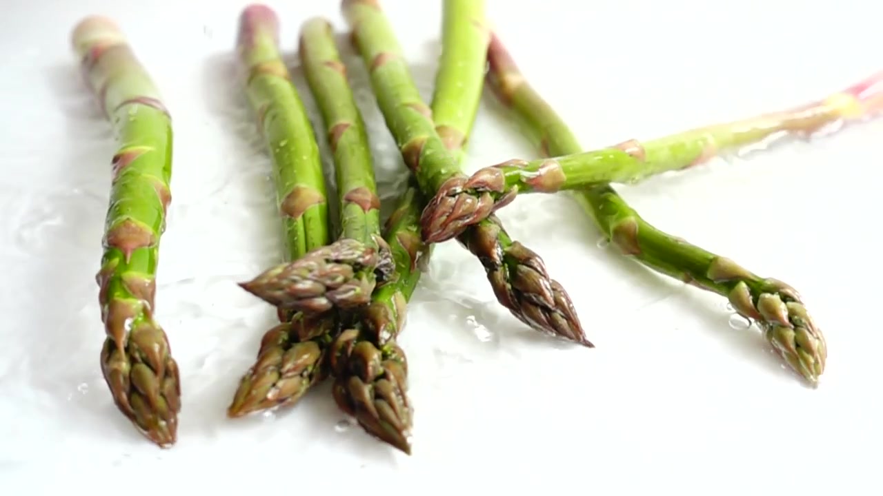 Asparagi verdi freschi. Schizzi d'acqua. Al rallentatore