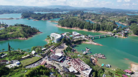 vista aérea del lago guatape y el paisaje de la región, agua turquesa, edificios y árboles verdes, colombia
