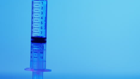 Video-of-laboratory-syringe-with-copy-space-on-blue-background