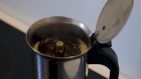 preparing a fresh black coffe in a mocha can